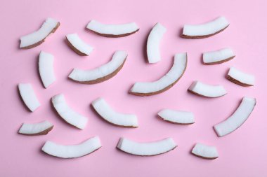 Fresh coconut pieces on pink background, flat lay clipart