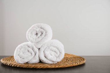 Temiz banyo havluları ve koyu gri masada hasır. Metin için boşluk