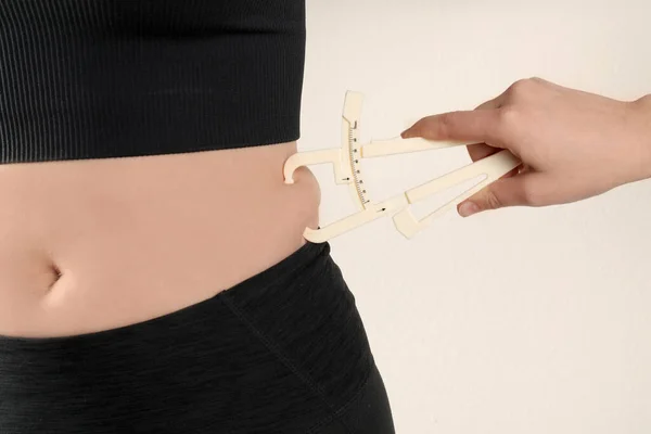 Nutritionist Measuring Woman Body Fat Layer Caliper Beige Background Closeup — Stock Photo, Image