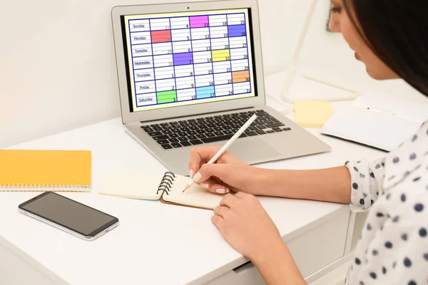 Mulher planejando sua agenda com aplicativo de calendário no laptop em offic — Fotografia de Stock