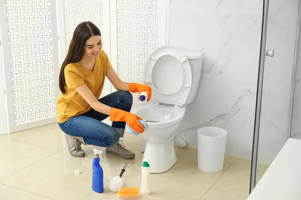 Giovane donna pulizia WC ciotola in bagno — Foto Stock