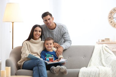 Evde kitap okuyan küçük oğlu olan mutlu bir aile. Kış tatili