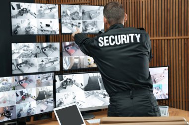 Mobil vericili güvenlik görevlisi modern CCTV 'yi izliyor. 