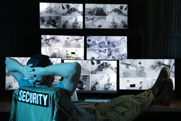 Security guard monitoring modern CCTV cameras at night — Stock Photo, Image