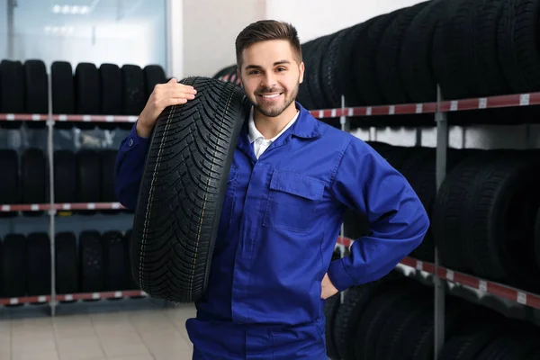 Mecánico Masculino Con Neumático Coche Tienda Automóviles —  Fotos de Stock