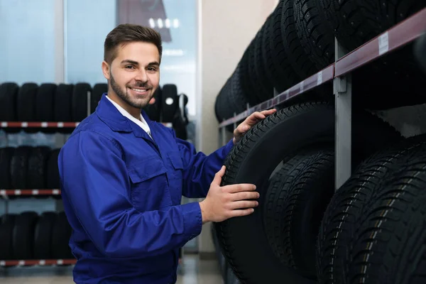 Mecánico Masculino Con Neumático Coche Tienda Automóviles —  Fotos de Stock