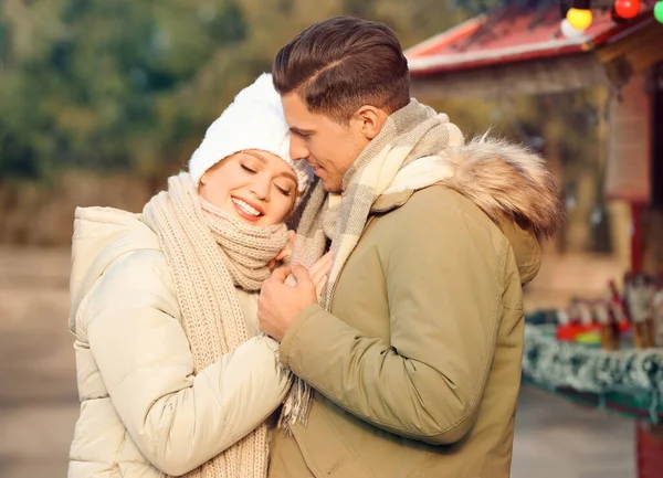 Happy couple in warm clothes at winter fair. Christmas season — Stock Photo, Image