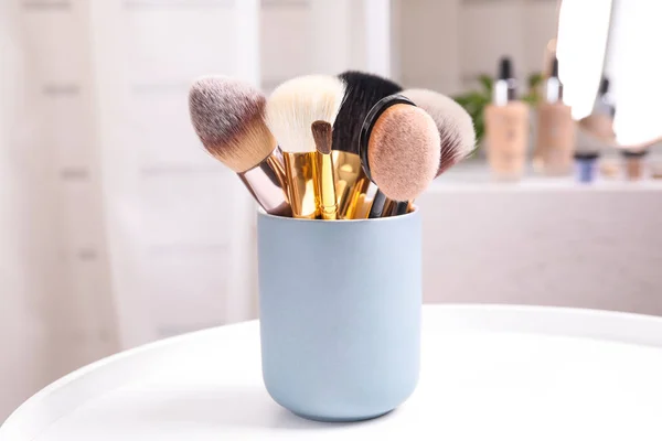 Set professioneller Make-up-Pinsel auf Schminktisch drinnen — Stockfoto