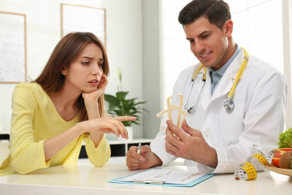 Nutricionista consulta paciente à mesa na clínica — Fotografia de Stock