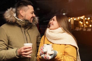 Happy couple with mulled wine at winter fair