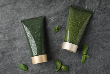 Gri taş masa üzerinde kozmetik ürünlerle düz kompozisyon