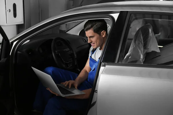 Mechanica met laptop doet auto kenmerkend bij auto reparatie s — Stockfoto