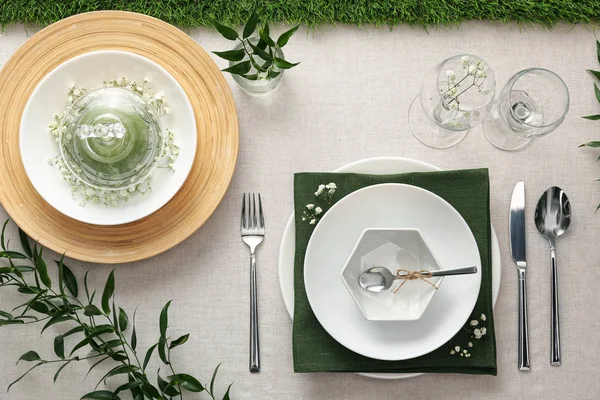 Elegant dukning med gröna växter på ljust tyg, platt liggunderlag — Stockfoto