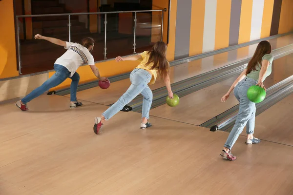 Group of friends throwing balls in bowling club — 스톡 사진