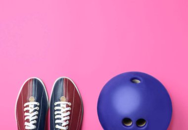 Pembe arka planda bowling topu ve ayakkabılar, düz yatış. t için boşluk