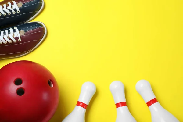 Bowling ball, shoes and pins on yellow background, flat lay. Spa — 스톡 사진