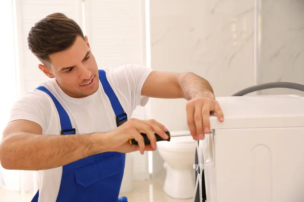 Professionele loodgieter repareren wasmachine in de badkamer — Stockfoto