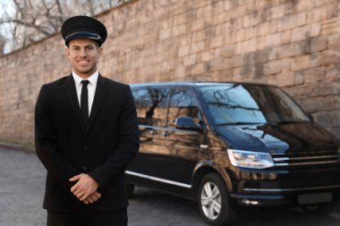 Sokakta lüks bir arabanın yanında profesyonel bir sürücü. Şoför servisi.