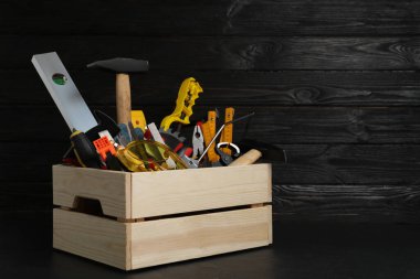 Siyah masa üzerinde farklı marangoz aletleri olan tahta sandık. Sp