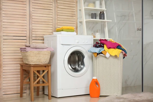 Cesta com lavandaria e máquina de lavar roupa no banheiro — Fotografia de Stock