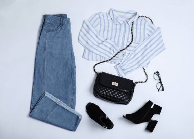 Stylish outfit with jeans on white background, top view
