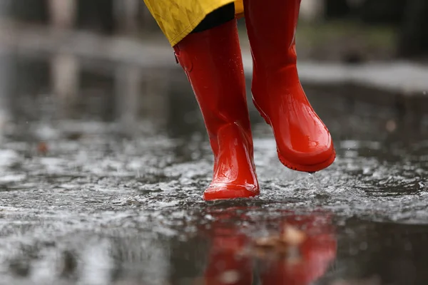 Vrouw in rubberen laarzen loopt buiten op regenachtige dag, close-up. Sp — Stockfoto