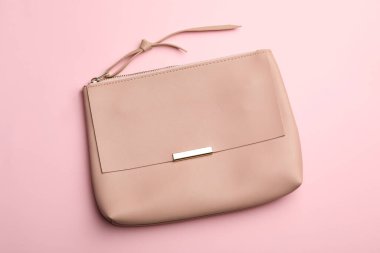 Pembe arka planda şık bir kadın çantası, üst manzara.