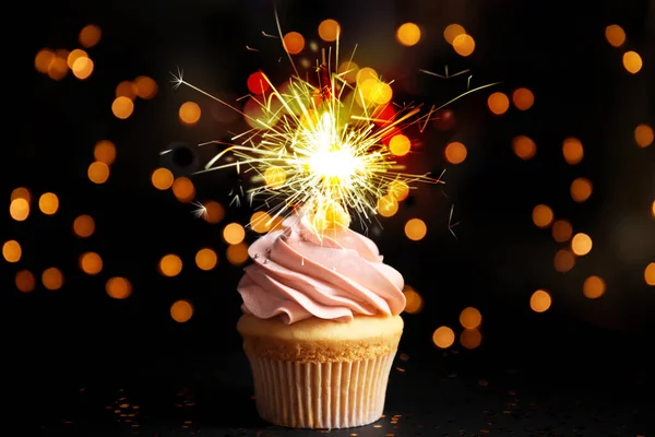 Beautiful birthday cupcake with sparkler on black table against — 스톡 사진