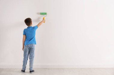 Beyaz duvarda paten fırçasıyla küçük çocuk resimleri. Metin için boşluk