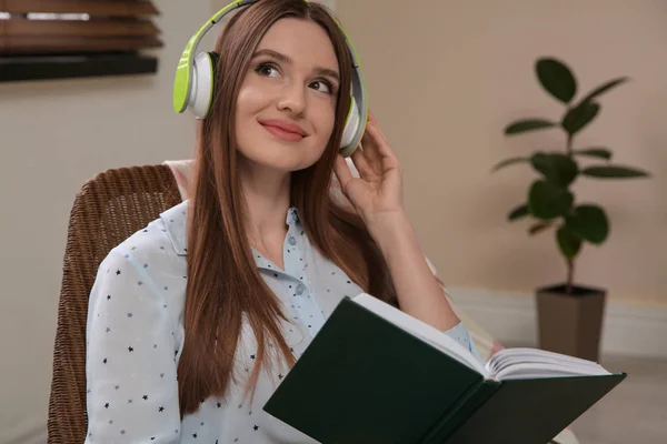 Woman listening to audiobook in chair at home — 스톡 사진