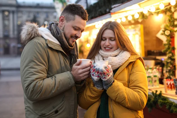 Happy couple with mulled wine at winter fair — Stock Photo, Image