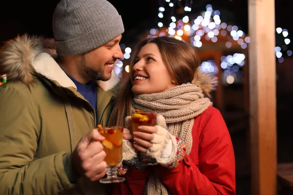 Casal feliz com vinho quente na feira de inverno — Fotografia de Stock