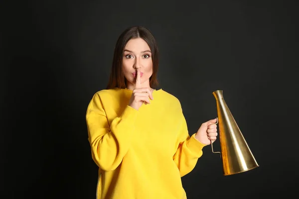 Jonge vrouw met megafoon op zwart achtergrond — Stockfoto