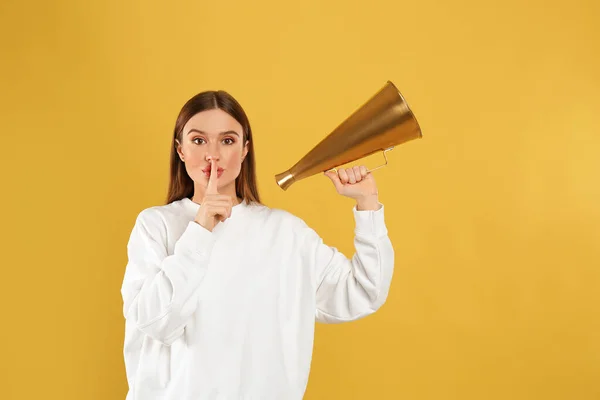 Mladá žena s vintage megaphone na žlutém pozadí — Stock fotografie