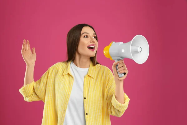 Ung kvinna med MegaFon på rosa bakgrund — Stockfoto