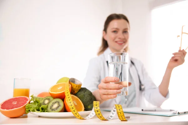 Nutricionista con vaso de agua, frutas, verduras y medidas — Foto de Stock
