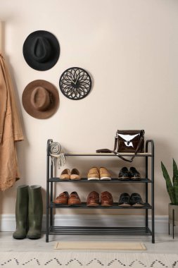 Odada bej duvarın yanında farklı ayakkabılar var.