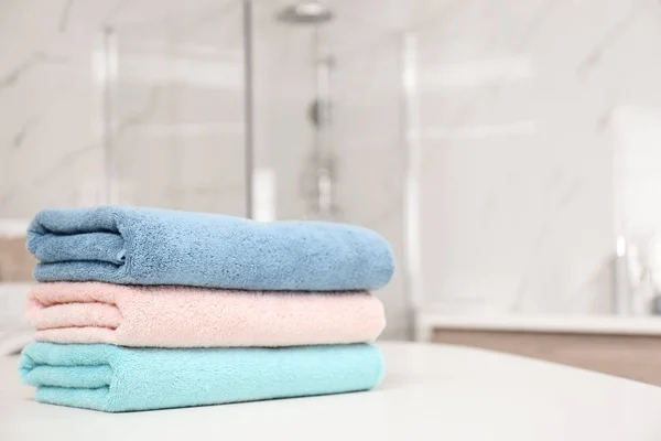 Montón de toallas frescas en la mesa blanca en el baño, primer plano. Espacio —  Fotos de Stock