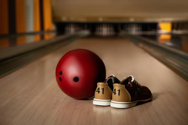 Pin, shoes and ball on alley in bowling club. Space for text Stock