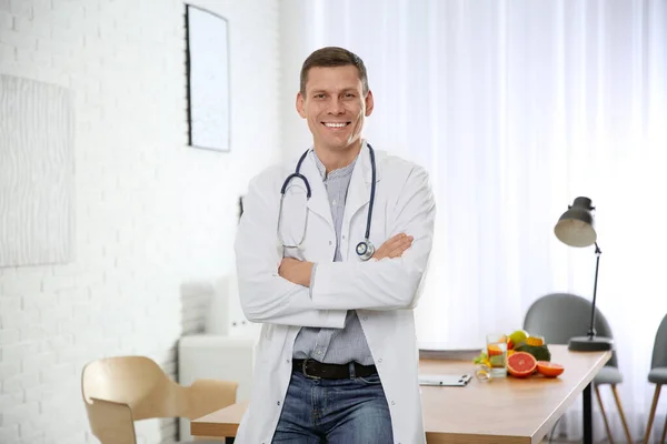 Nutritionist with stethoscope near desk in office — 스톡 사진