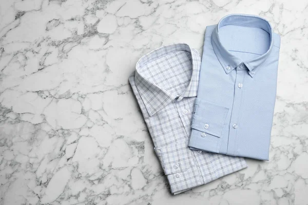 Camisas masculinas con estilo sobre fondo de mármol, planas. Espacio para te — Foto de Stock