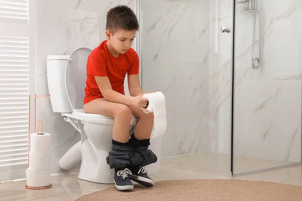 安静な部屋のトイレのボウルに痔に苦しんでいる紙と少年 — ストック写真