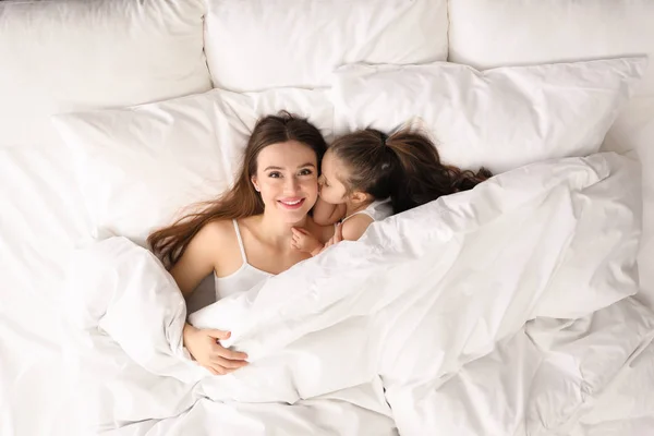 Mother and little daughter lying in bed, top view — 스톡 사진