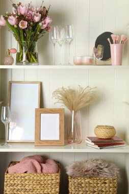 White shelving unit with glassware and different decorative elements