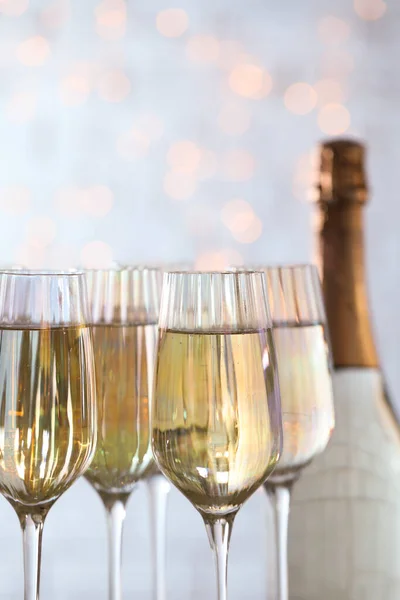 Bril champagne en fles tegen wazig licht, close-up — Stockfoto