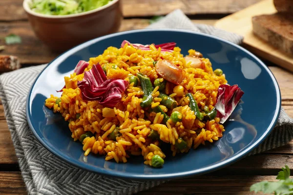 Delicioso pilaf de arroz com frango e legumes na mesa de madeira — Fotografia de Stock