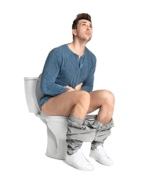 トイレの上で胃の痛みに苦しんでいる男 白い背景 — ストック写真