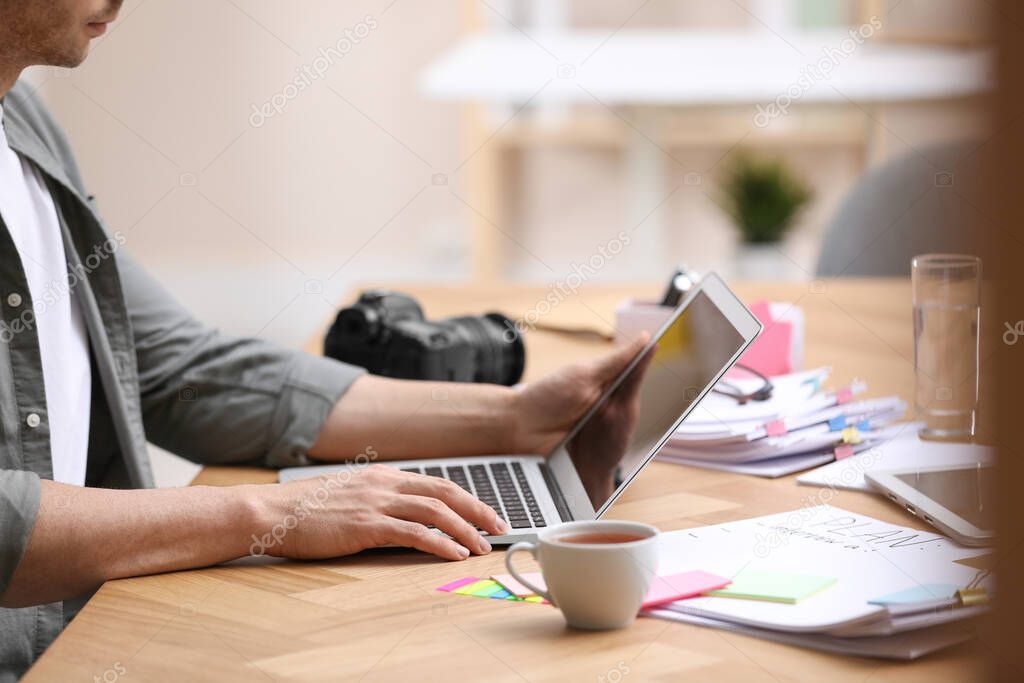 Professional journalist working with laptop in office, closeup