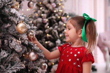 Cute little child near Christmas tree at home