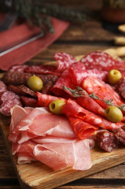Tasty prosciutto with other delicacies served on wooden table